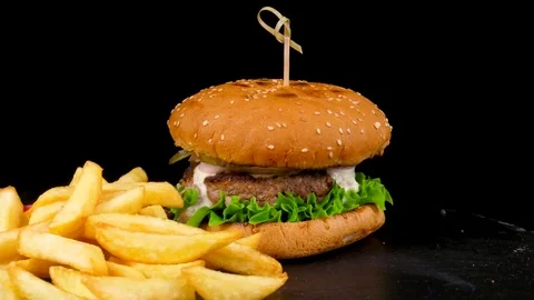 Beef burger with pickled cucumbers, served with Fried Potato wedges Stock Footage 84655577