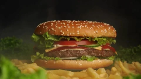 Beef Burger rotating on the table on a black background. plate on grey Video stock 336578773