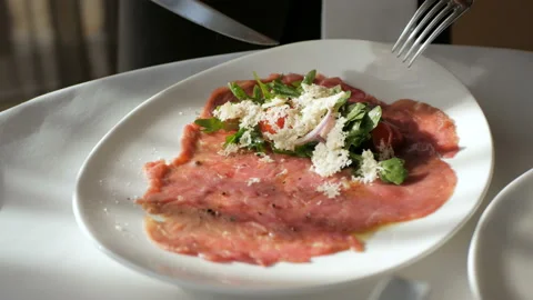 Beef carpaccio with Parmesan, cherry tomatoes, red onion and arugula Stock Footage 101846481