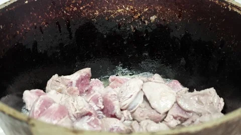 Beef chunks sizzling in dark skillet with rendered juices and browned edges Video stock 343644051