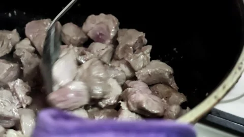 Beef chunks sizzling in dark skillet with rendered juices and browned edges Video stock 343644102