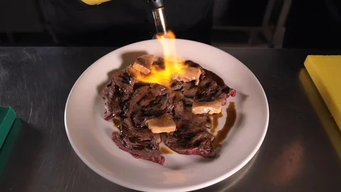Beef cooking with fire on the plate close plan Stock Footage 89598536