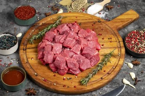Beef cubed. Fresh raw beef diced meat on dark background. Butcher products Stock Photos