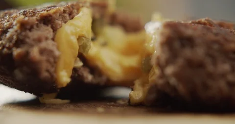 Beef cutlet for burger in section with cheese viscous filling. 4K Slow Motion Stock Footage 117405668