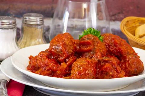 Beef dumpling in tomato sauce in a plate on a table Stock Photos