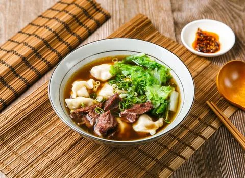 Beef dumplings soup with meat, chilli sauce, spring onion, wooden spoon, an.. Stock Photos