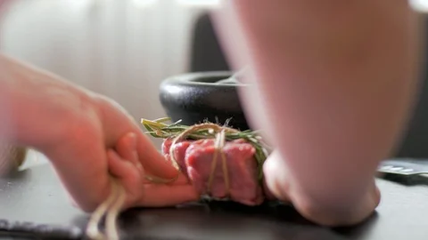 Beef fillet slices wrapped being secure with  twine Stock Footage 106923857
