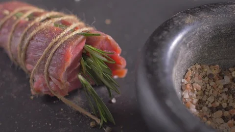 Beef fillet slices wrapped being secure with  twine. slow motion Video stock 106924032