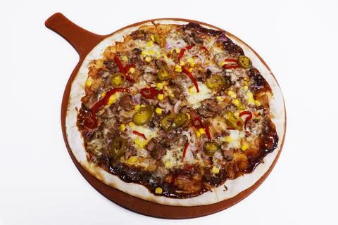 Beef flatbread pizza with BBQ sauce, corn, peppers and herbs Stock Photos