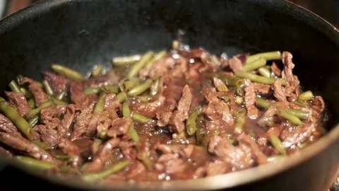 Beef fried in frying pan with onion and green beans. Meat preparation Stock Footage 75055301