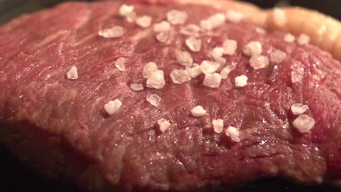 The beef is fried in a pan, black pepper is poured onto it, pan left Stock Footage 113553478