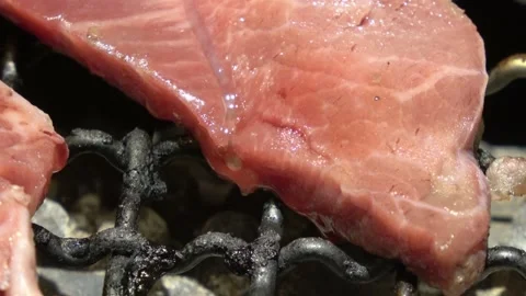 Beef is grilling, with juices overflowing on the grate. Vídeos de archivo 313493593