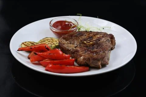 Beef kebabs on a plate with grilled vegetables, zucchini and Bulgarian red pe Stock Photos