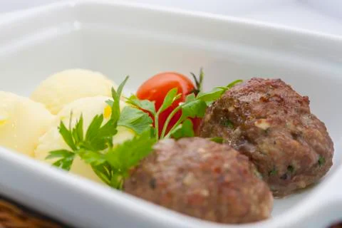 Beef meat balls with mashed potatoes and pickled tomatoes in a wicker basket Stock Photos