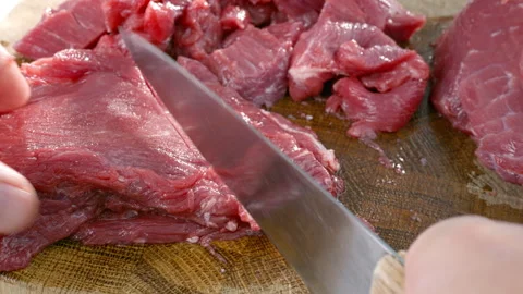 Beef meat is cut with a knife to be cooked. Stock Footage 311885934