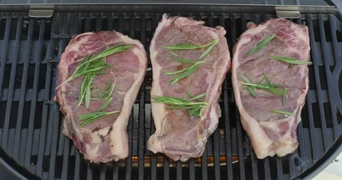 Beef meat steak with rosemary roasting on barbecue grill. Backyard BBQ. Smoke Stock Footage 274581847
