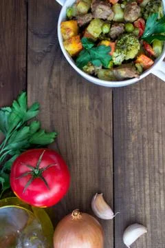 Beef meat stewed with vegetables in ceramic pot with ingredients on wooden Foto stock