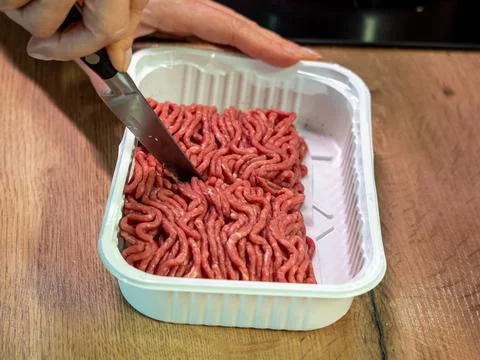 Beef meat in white plastic packaging cut with a knife, top view Stock Photos