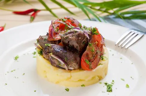 Beef with onions, tomatoes and mashed potatoes Stock Photos