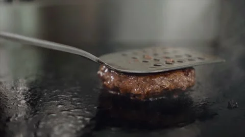 The beef or pork cutlet is grilled, the chef presses the cutlet with an iron Stock Footage 153264526