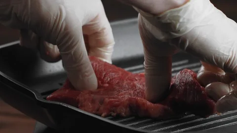 Beef or pork steak put on dry grill pan in kitchen or in restaurant to fry Stock Footage 123571681