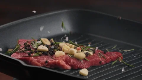 Beef or pork steak with salt pepper garlic and rosemary falls on hot grill pan Stock Footage 123571814