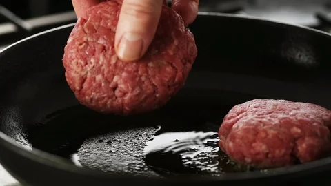 Beef patty gently placed in a hot cast iron pan, two in frame. Stock Footage 92150737