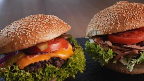 Beef, pulled pork and chicken hamburgers in a row - camera slide in a circle Video stock 105721411
