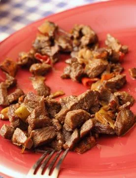 Beef on red plate 库存照片