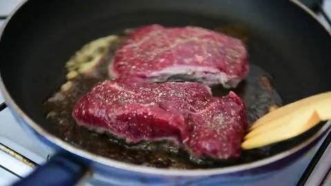 Beef ribeye steak being fried in a pan on the stove 스톡 동영상 69205650