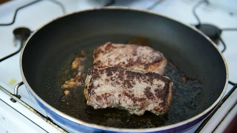 Beef ribeye steak being fried in a pan on the stove 스톡 동영상 69205651