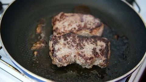 Beef ribeye steak being fried in a pan on the stove Vídeo Stock 69205661