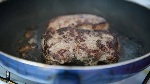 Beef ribeye steak being fried in a pan on the stove Stockbeeldmateriaal 69205662