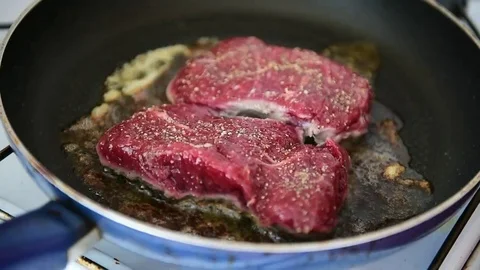Beef ribeye steak being fried in a pan on the stove Video stock 69205664