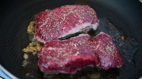 Beef ribeye steak being fried in a pan on the stove Video stock 69205669
