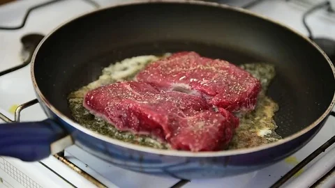 Beef ribeye steak being fried in a pan on the stove Video stock 69205673
