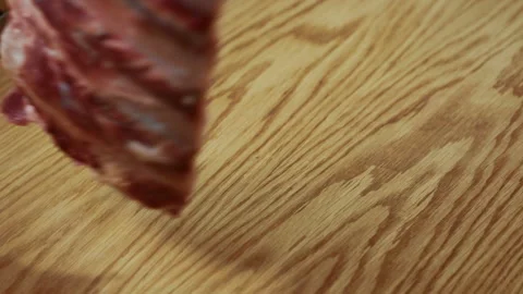Beef ribs are being put to the wooden cutting board on the kitchen of restaurant Stock Footage 87323199