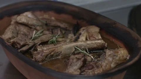 Beef ribs in a clay pot garnished with rosemary Stockbeeldmateriaal 72308988