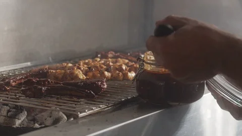 Beef ribs on a wire rack are coated with brush with teriyaki sauce Stock Footage 123768699