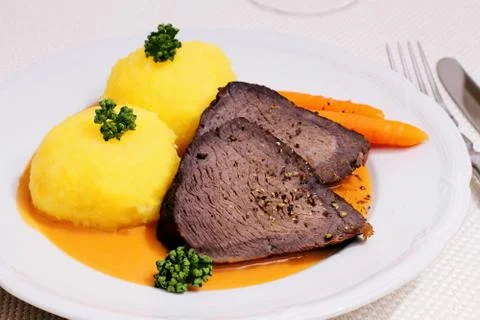 Beef roast, two dumplings in hunter sauce Stock Photos