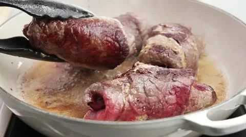 Beef roulade being turned in hot oil Stock Footage 24647947