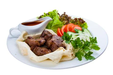 Beef shish kebab in pita bread. On a white plate Stock Photos
