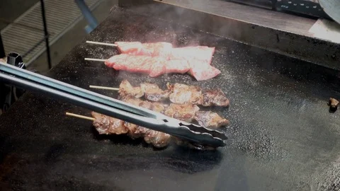 Beef skewers grilled while cooked on a hot plate Stock Footage 84927085