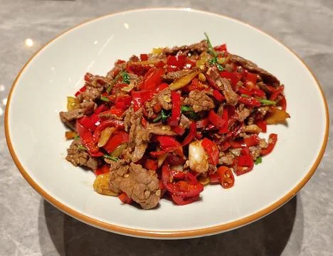 Beef slice scrambled with red pepper on the white plate for eating Stock Photos