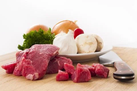 Beef steak and mixed vegetables on a cutting board ready for making dinner Stock Photos
