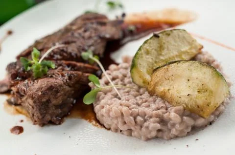 Beef steak and wheat risotto in a plate at restaurant Stock Photos