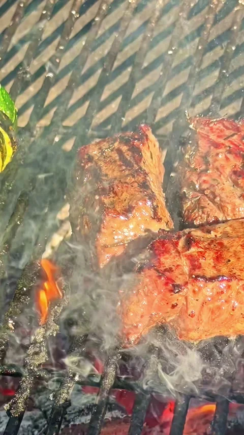 Beef steak and zucchini cooking on a flaming charcoal barbecue grill Stock Footage 337386549