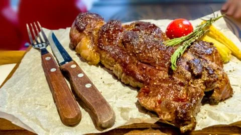 Beef steak is on the Board with a fork and a knife Stock Photos