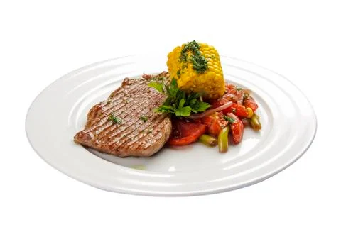 Beef steak with corn and vegetables. On a white background Stock Photos