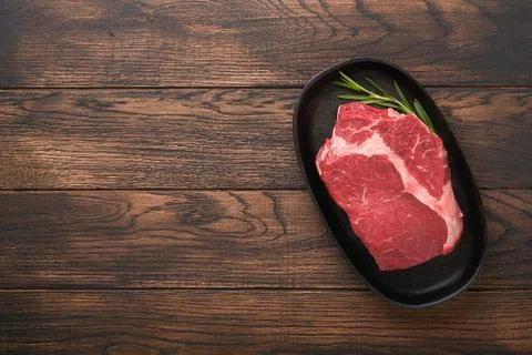 Beef steak. Fresh raw beef rib eye steak with fork rosemary, salt and pepper  Stock Photos